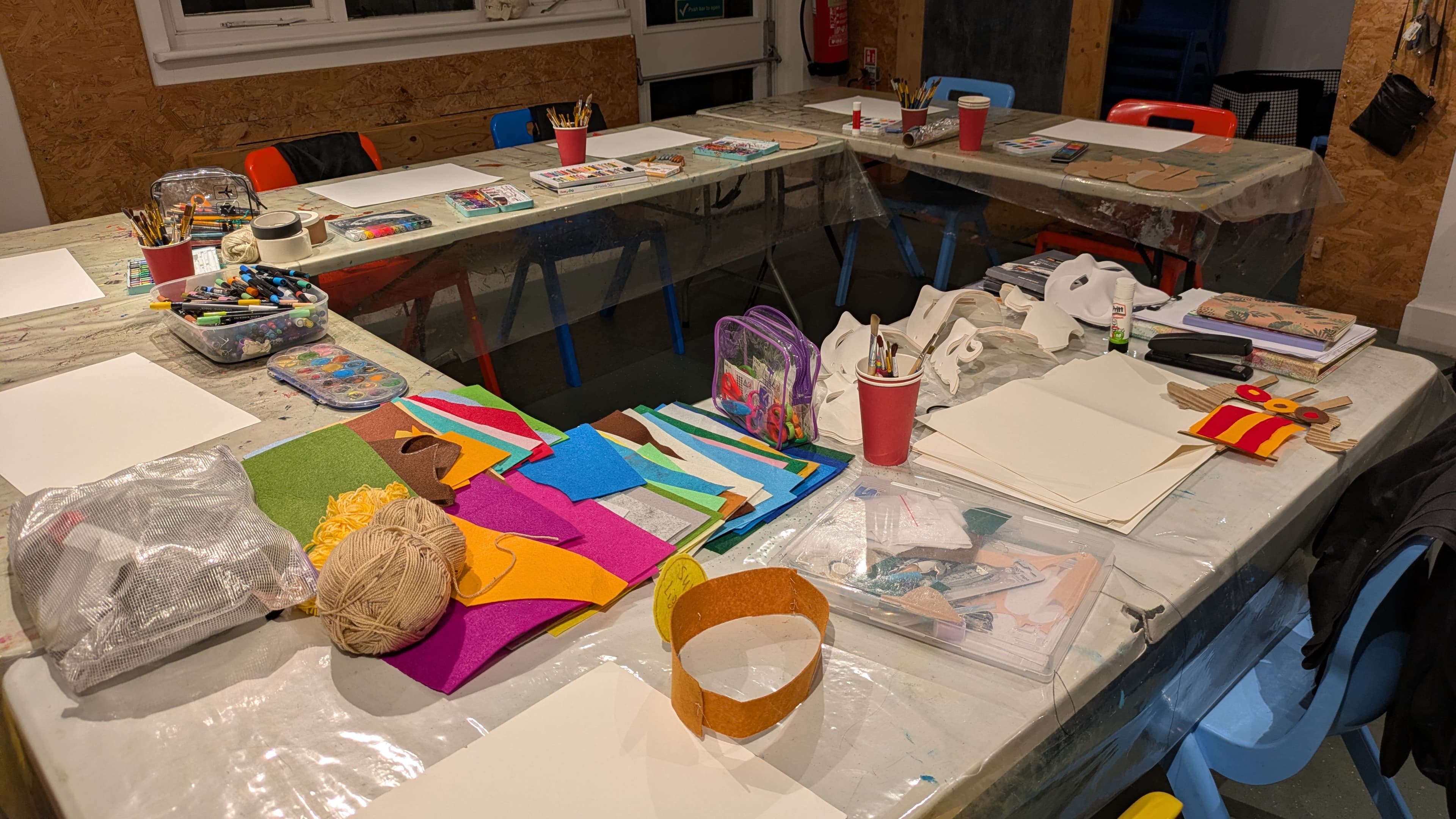 Art class set up with tables filled with different art materials