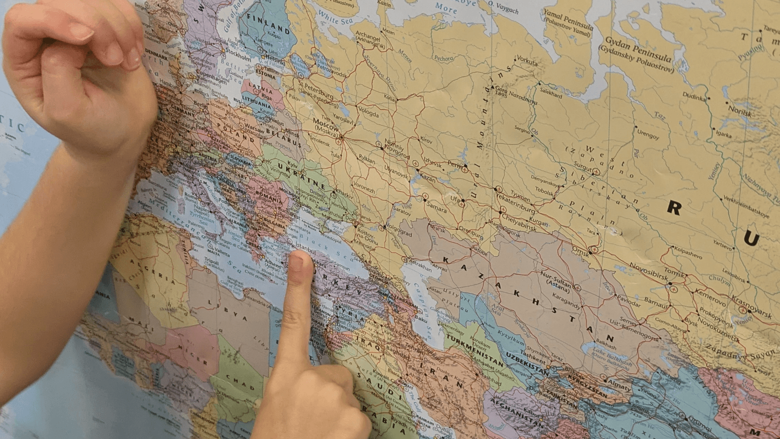 child's finger is pointing at certain place on a map