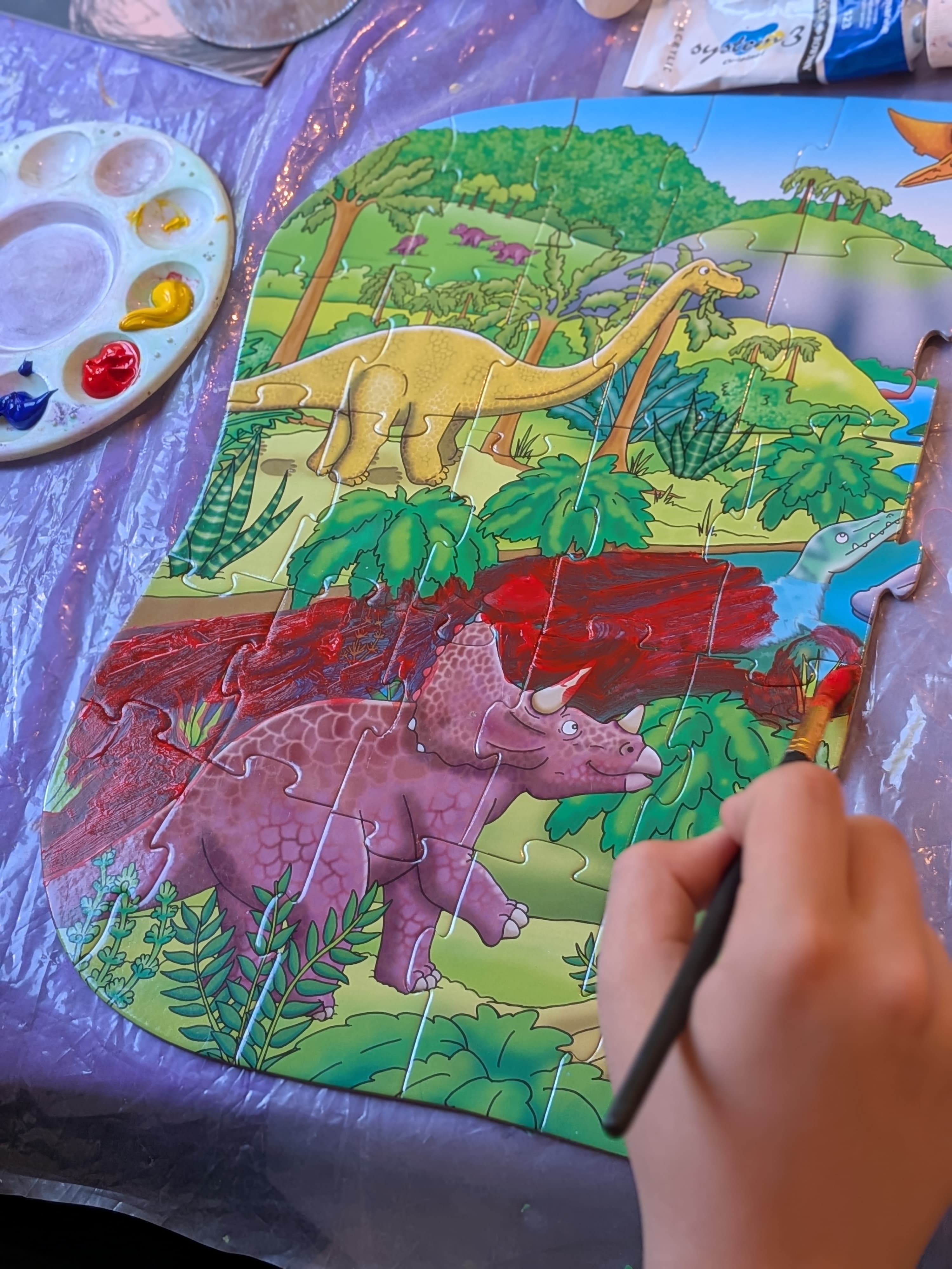 Dinosaur jigsaw being painted over