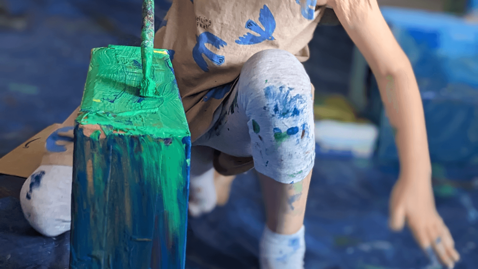 child painting in a messy clothes
